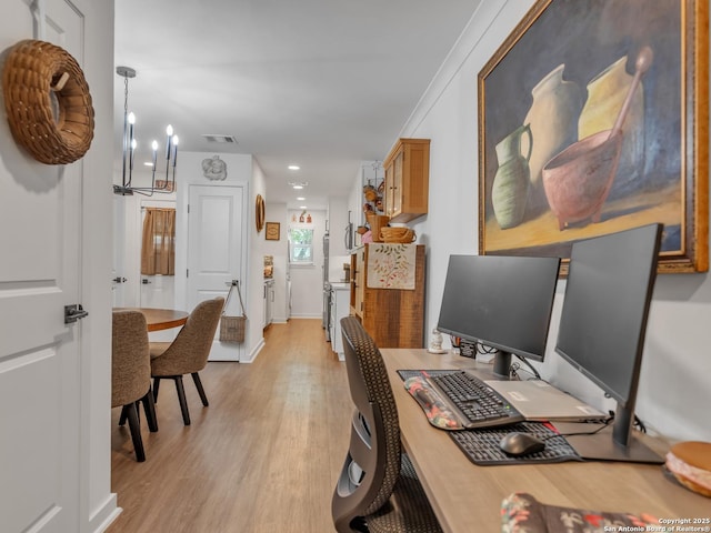 office featuring light hardwood / wood-style floors, ornamental molding, and a notable chandelier