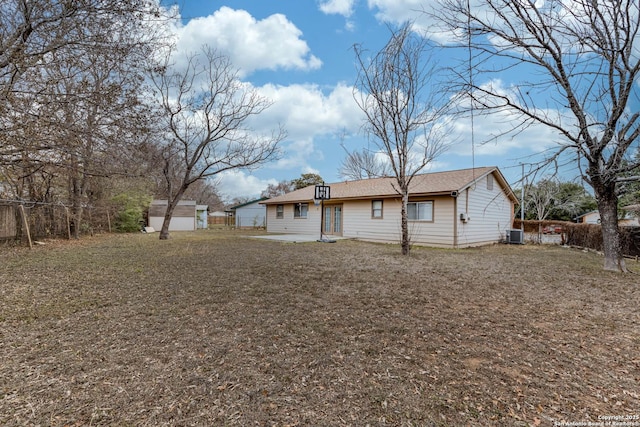 rear view of property with a lawn and central AC