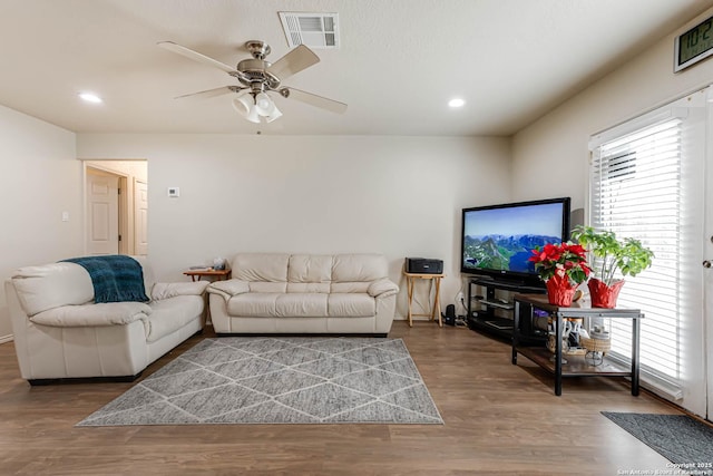 living room featuring wood-type flooring and ceiling fan