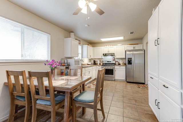 kitchen featuring sink, light tile patterned flooring, white cabinetry, and appliances with stainless steel finishes