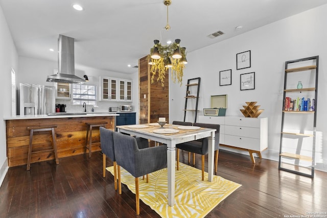 dining space featuring sink, dark hardwood / wood-style flooring, and an inviting chandelier