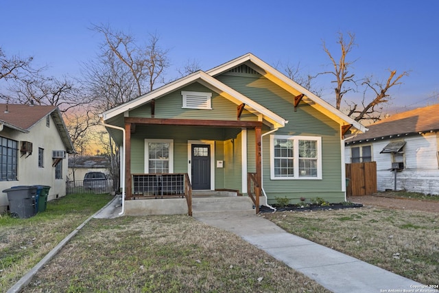 bungalow-style home with covered porch and a yard