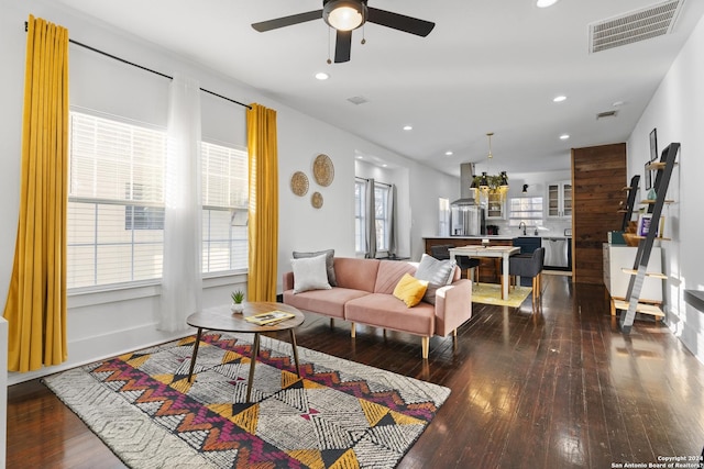 living room featuring ceiling fan, a wealth of natural light, and dark hardwood / wood-style floors