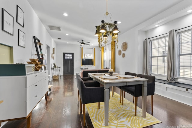 dining area with ceiling fan with notable chandelier and dark hardwood / wood-style floors