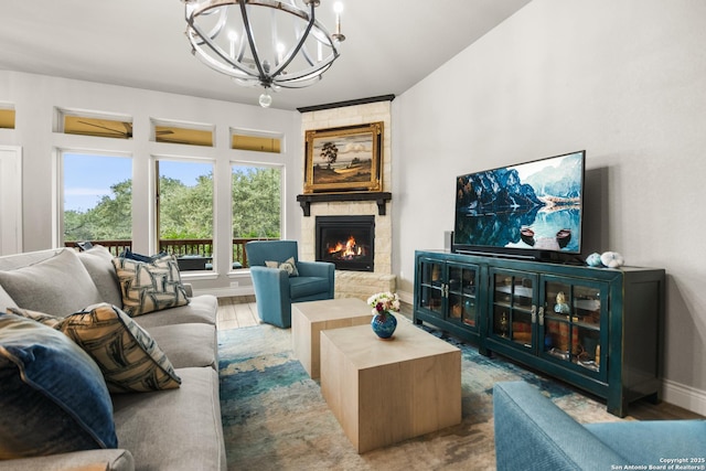 living room with wood-type flooring, a fireplace, and a notable chandelier