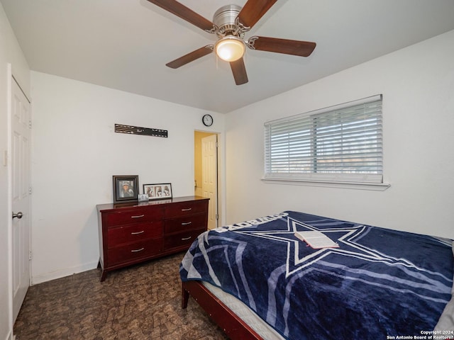 bedroom featuring ceiling fan and dark colored carpet