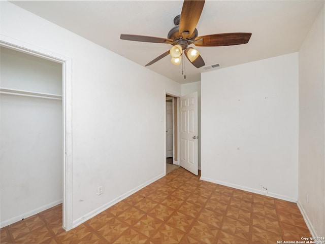 unfurnished bedroom with light parquet flooring and ceiling fan