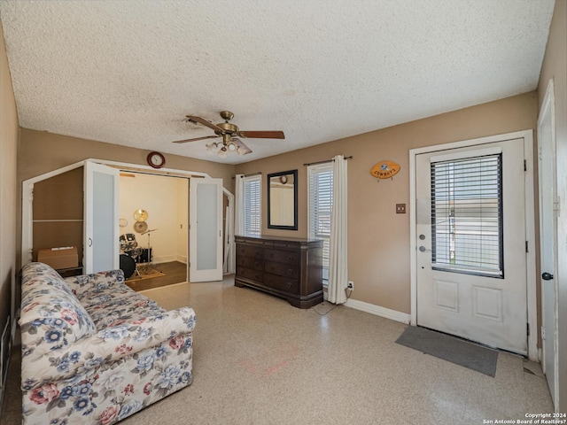 living room featuring a textured ceiling and ceiling fan