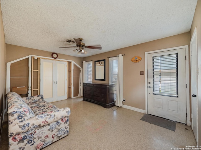 foyer featuring a textured ceiling, french doors, and ceiling fan