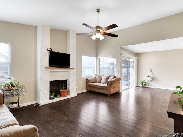 living room with a fireplace, ceiling fan, and dark wood-type flooring