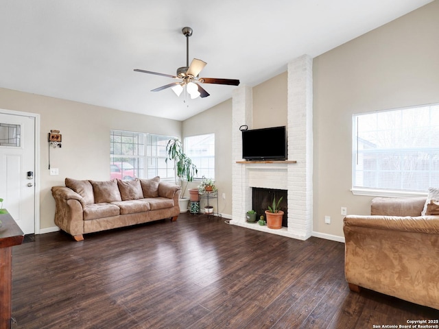 living room with ceiling fan, dark wood-type flooring, a brick fireplace, and vaulted ceiling