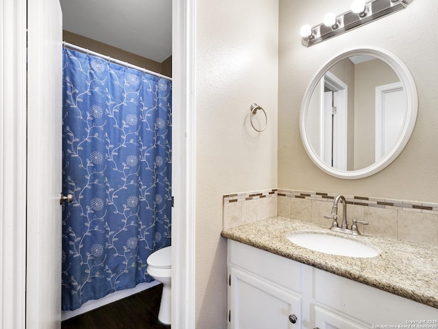 bathroom with vanity, hardwood / wood-style floors, tasteful backsplash, and toilet