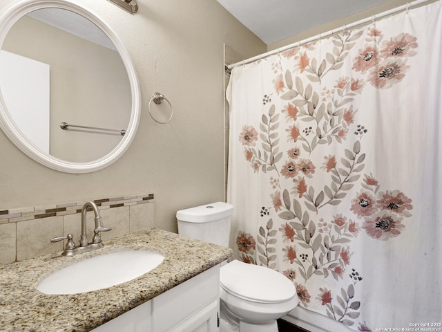 bathroom featuring toilet, vanity, and backsplash