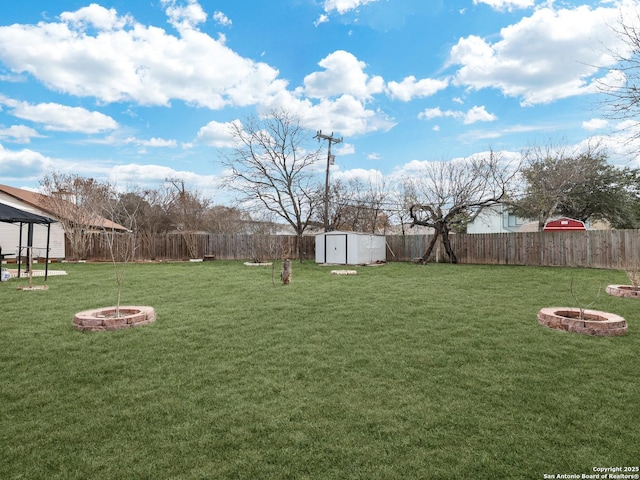 view of yard featuring a fire pit and a storage shed