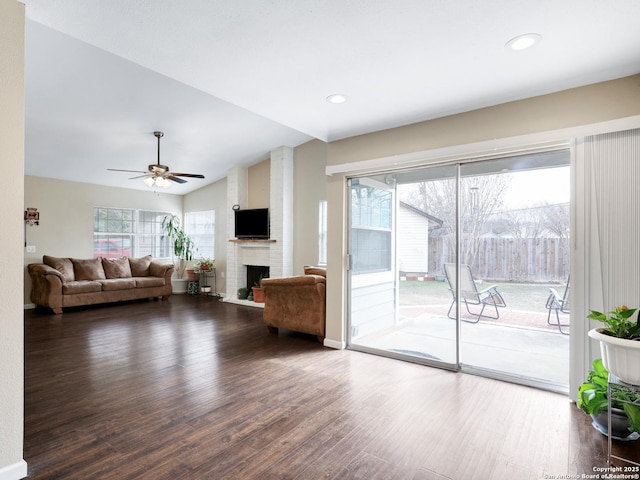 unfurnished living room with a brick fireplace, ceiling fan, vaulted ceiling, and hardwood / wood-style flooring