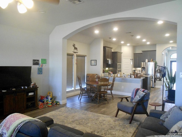 living room with vaulted ceiling, ceiling fan, and dark hardwood / wood-style flooring