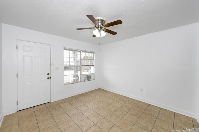 empty room with a ceiling fan, a textured ceiling, and baseboards