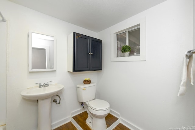 bathroom with toilet, sink, and hardwood / wood-style flooring