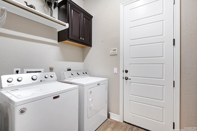 laundry room with washer and dryer and cabinets