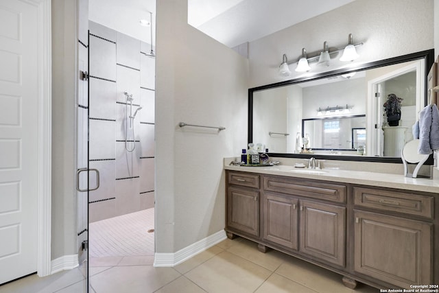 bathroom featuring a shower with door, vanity, and tile patterned floors