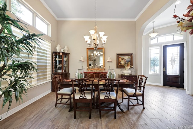 dining area featuring an inviting chandelier, hardwood / wood-style flooring, and crown molding