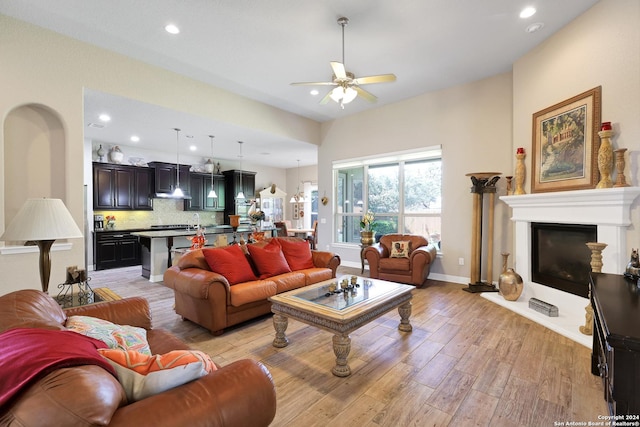 living room featuring ceiling fan, light hardwood / wood-style flooring, and sink