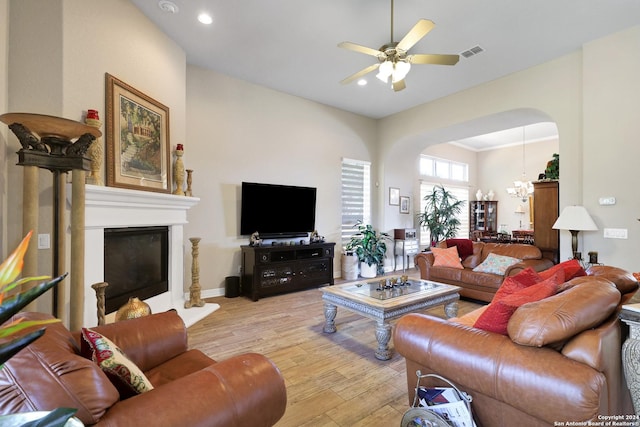 living room featuring ceiling fan, light wood-type flooring, and crown molding