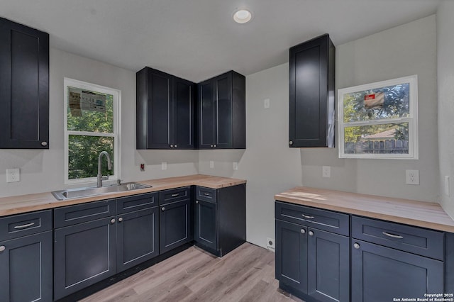 kitchen with sink, wooden counters, and light hardwood / wood-style floors