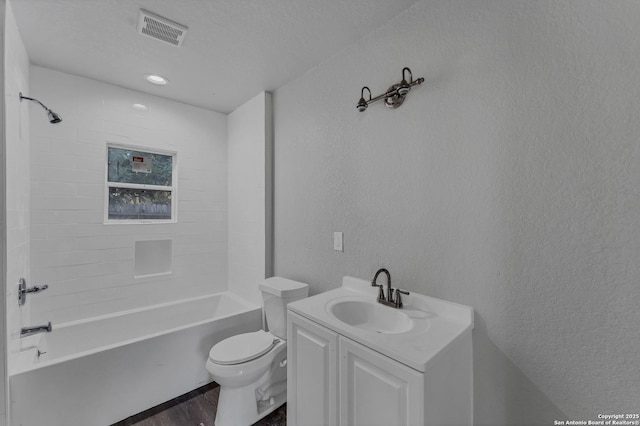 full bathroom with toilet, hardwood / wood-style flooring, a textured ceiling, bathing tub / shower combination, and vanity