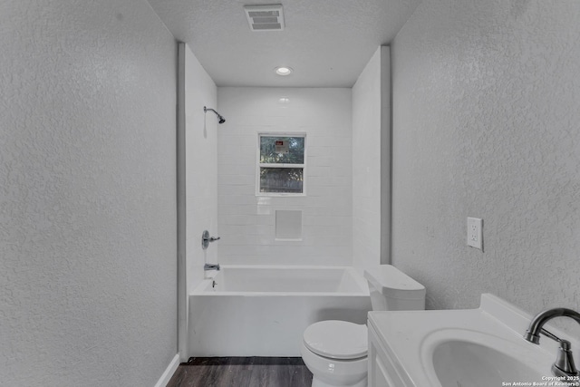 full bathroom featuring toilet, a textured ceiling, shower / bath combination, wood-type flooring, and vanity