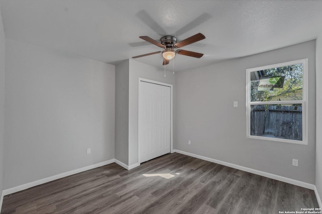 unfurnished bedroom featuring dark hardwood / wood-style flooring, a closet, ceiling fan, and a textured ceiling