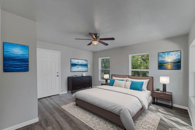 bedroom with a textured ceiling, ceiling fan, and hardwood / wood-style flooring