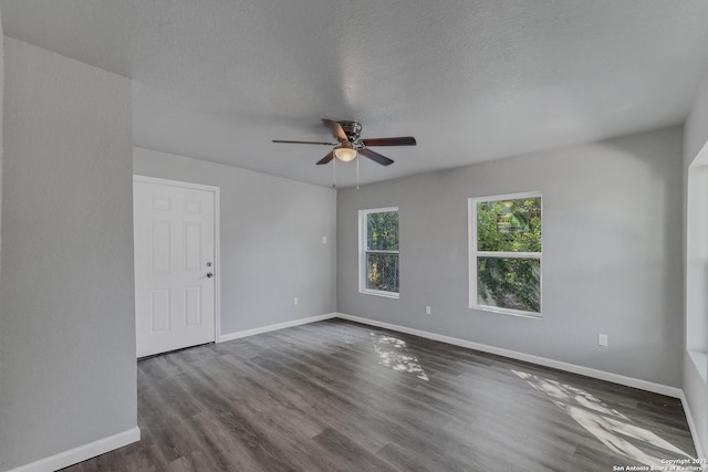 empty room featuring ceiling fan, a textured ceiling, and dark hardwood / wood-style floors