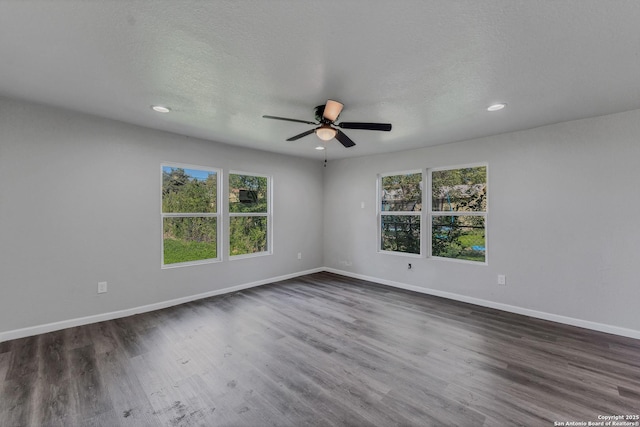 empty room with a textured ceiling, dark wood-type flooring, and ceiling fan