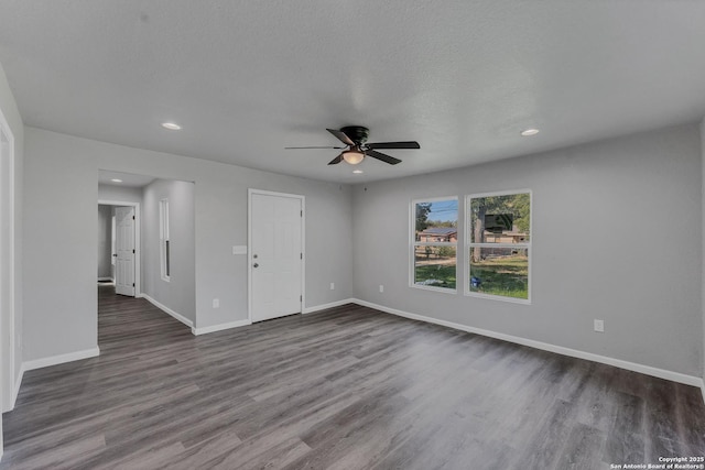 unfurnished room featuring a textured ceiling, ceiling fan, and dark hardwood / wood-style floors