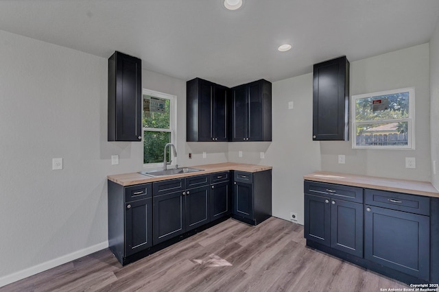 kitchen featuring sink, wooden counters, and light hardwood / wood-style floors