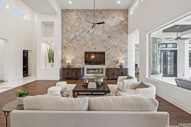 living room with a healthy amount of sunlight, a fireplace, and a high ceiling