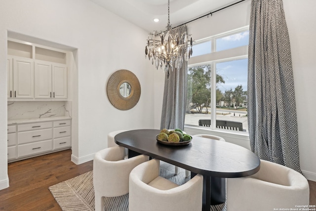 dining area with a notable chandelier and dark hardwood / wood-style floors