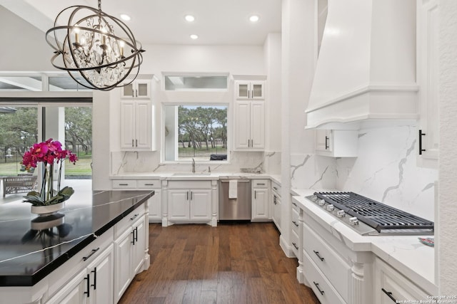 kitchen featuring custom exhaust hood, dark hardwood / wood-style floors, decorative light fixtures, white cabinets, and appliances with stainless steel finishes