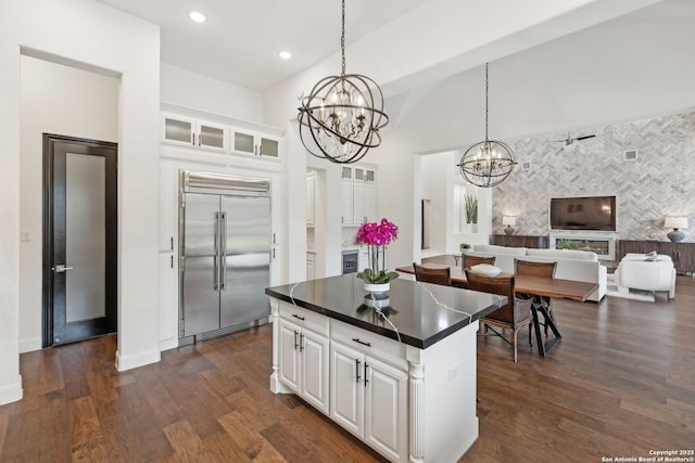 kitchen with pendant lighting, built in refrigerator, white cabinetry, and a kitchen island