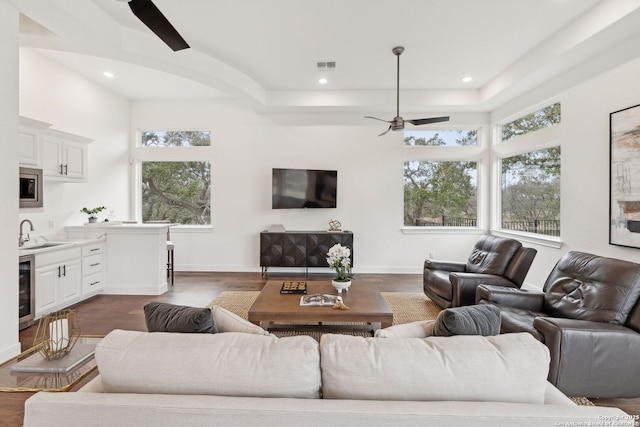 living room featuring beverage cooler, dark hardwood / wood-style flooring, and sink