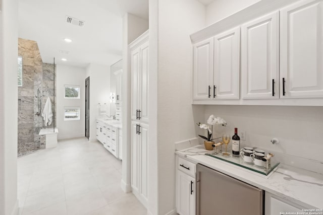 bar featuring white cabinets and light stone counters