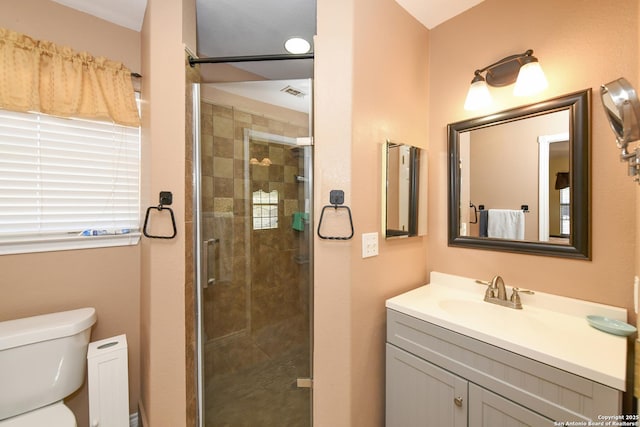 bathroom featuring vanity, toilet, and walk in shower