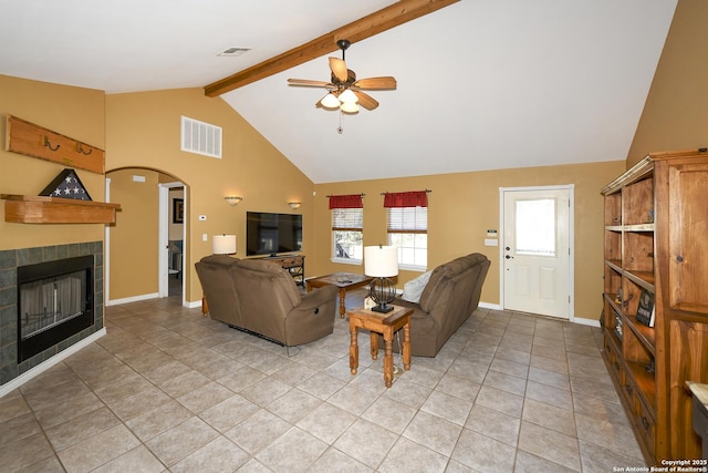 tiled living room with a tiled fireplace, ceiling fan, high vaulted ceiling, and beamed ceiling