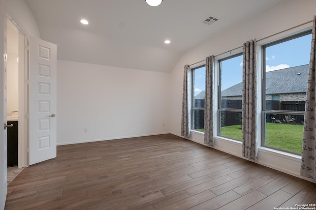 unfurnished room featuring lofted ceiling and plenty of natural light