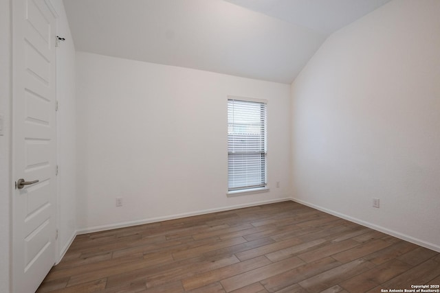 unfurnished room with lofted ceiling and dark hardwood / wood-style floors