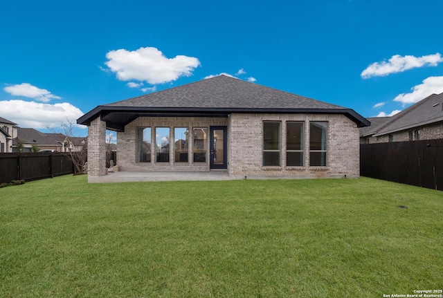 rear view of house featuring a yard and a patio