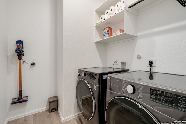 laundry area with washer and dryer and light wood-type flooring