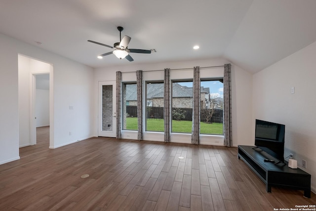 unfurnished living room with dark hardwood / wood-style flooring, lofted ceiling, and ceiling fan