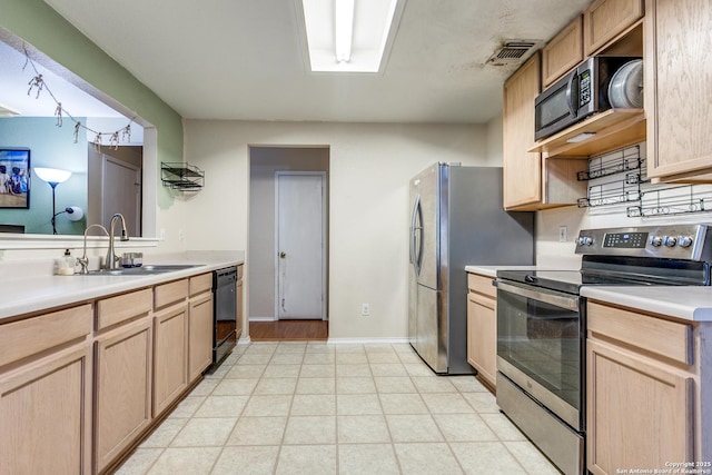 kitchen with stainless steel appliances, light brown cabinets, and sink